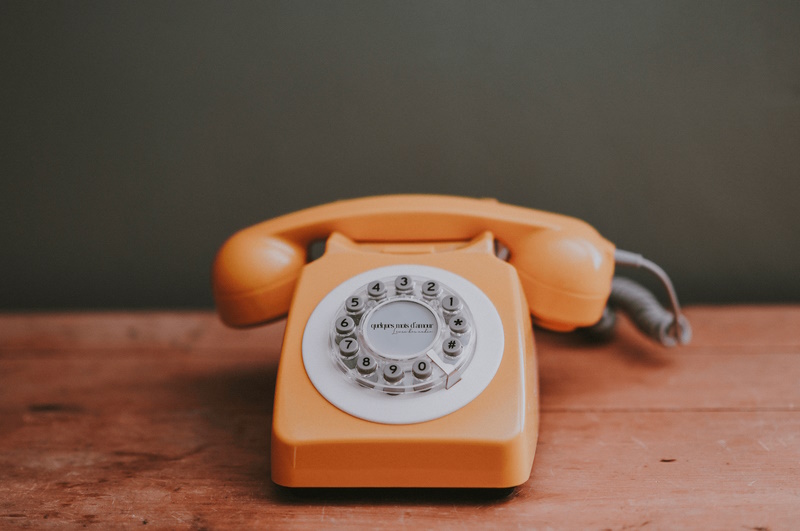 Téléphone orange posé sur une table en bois