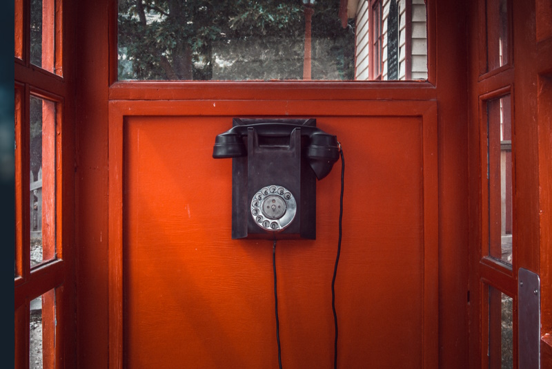 téléphone noir dans une cabine téléphonique rouge