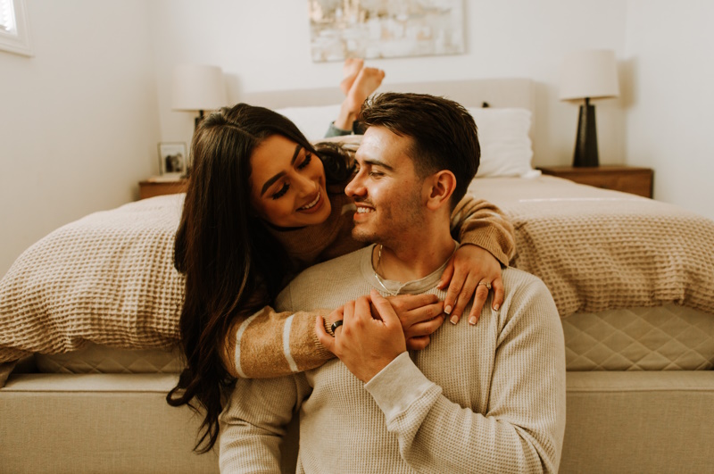 une femme et un homme qui se font un calin dans une chambre